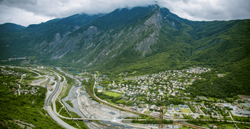 Vue aérienne de la vallée de la Maurienne montrant les infrastructures de transport, un cours d’eau et les zones concernées par le projet Lyon-Turin.
