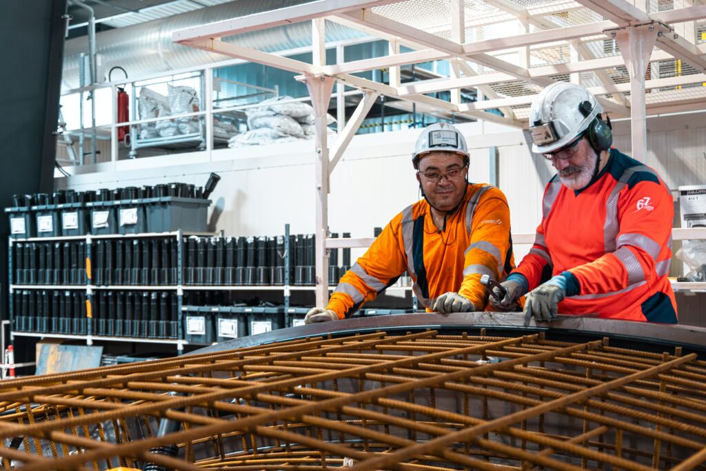 Deux salariés produisant des voussoirs, grands anneaux de béton qui recouvriront les parois du tunnel Lyon-Turin