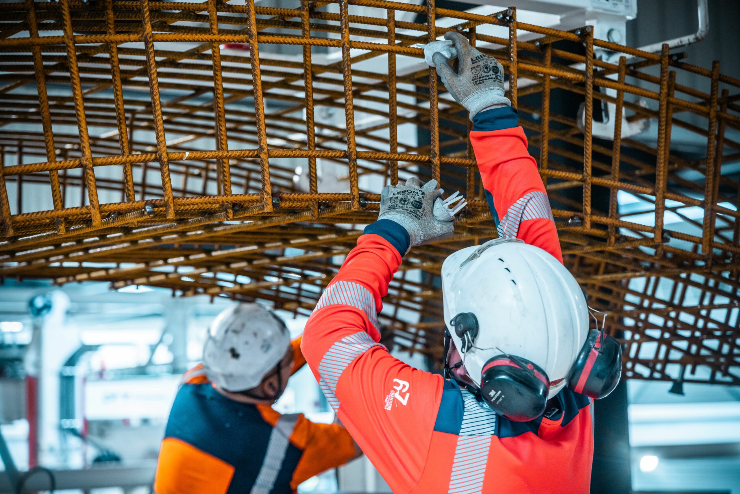Deux salariés produisant des voussoirs, grands anneaux de béton qui recouvriront les parois du tunnel Lyon-Turin